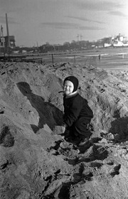 Lapsi lapioi hiekkaa Sörnäisten rannassa